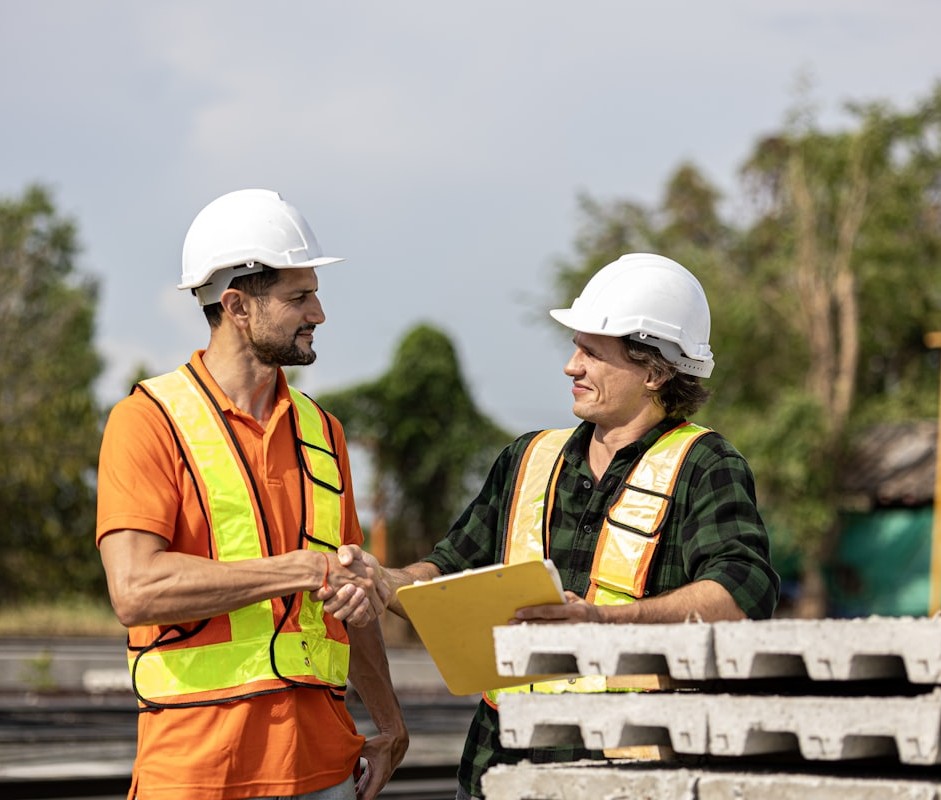 Property manager and contractor shaking hands on a construction site